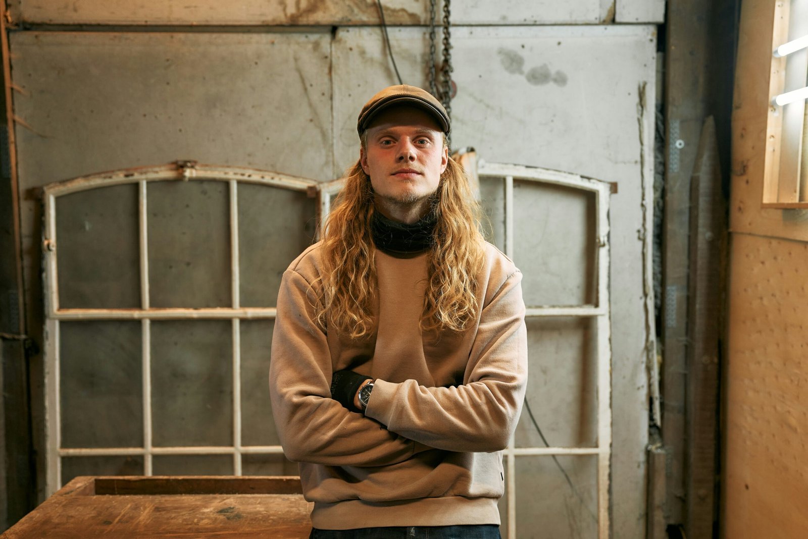 A man standing in front of a window with his arms crossed